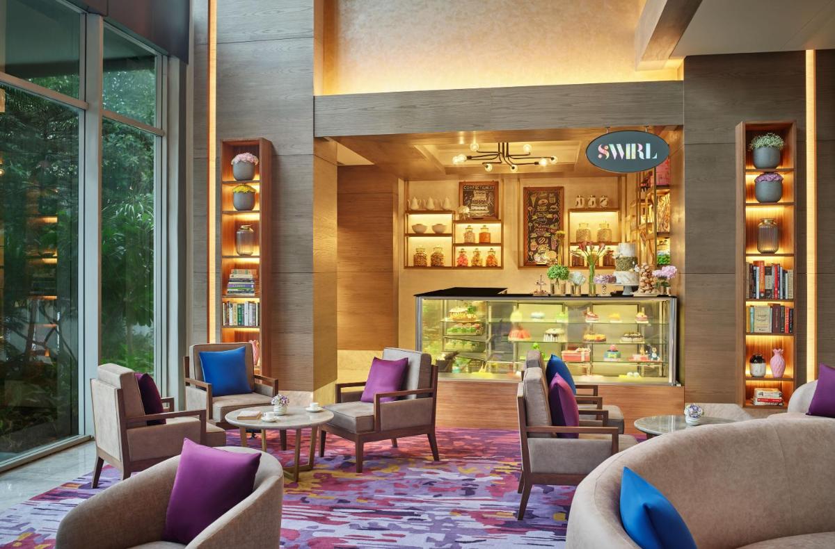 a lobby with chairs and tables and a store at Vivanta Kolkata EM Bypass in Kolkata