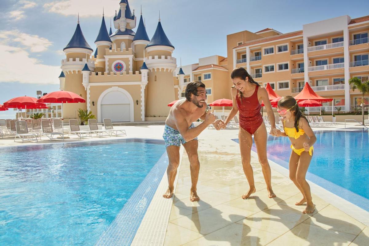 un grupo de personas parados junto a una piscina en un complejo en Bahia Principe Fantasia Tenerife - All Inclusive, en San Miguel de Abona