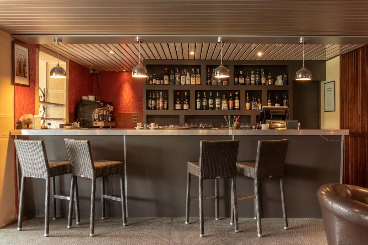 un bar dans un restaurant avec des chaises autour de lui dans l'établissement Auberge Du Camp Romain, à Chassey-le-Camp