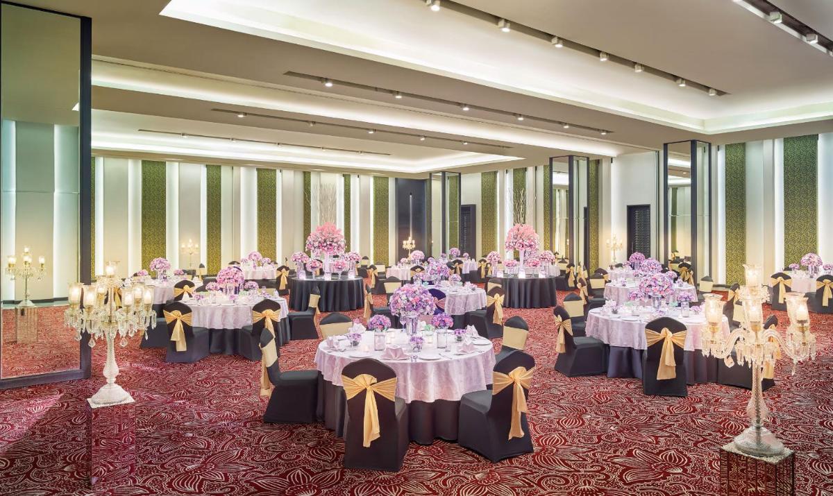 a ballroom with tables and chairs with pink flowers at Vivanta Kolkata EM Bypass in Kolkata +66 photos