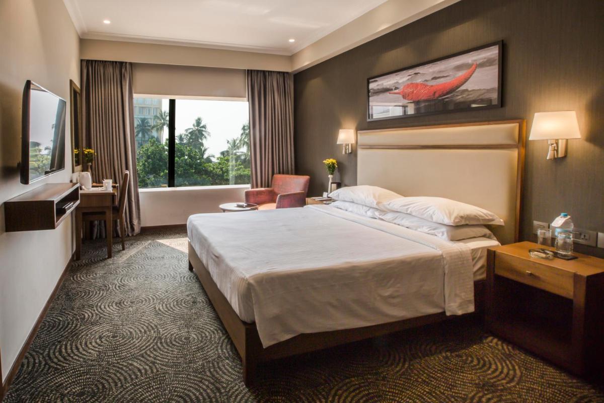a hotel room with a large bed and a bathroom at Sun-n-Sand Mumbai Juhu Beach in Mumbai