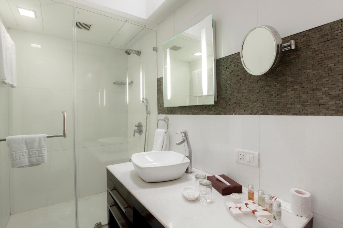 a white bathroom with a sink and a shower at Sun-n-Sand Mumbai Juhu Beach in Mumbai