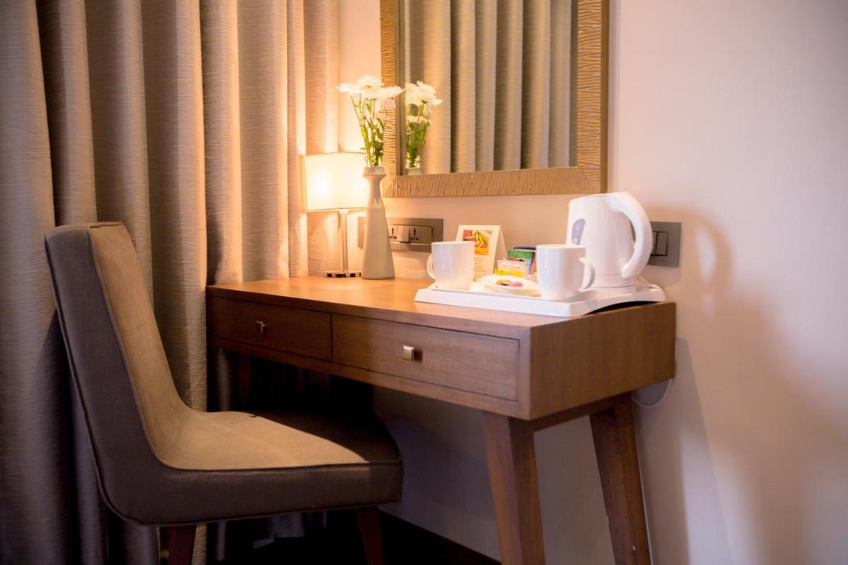 a desk in a hotel room with a chair and a mirror at Sun-n-Sand Mumbai Juhu Beach in Mumbai