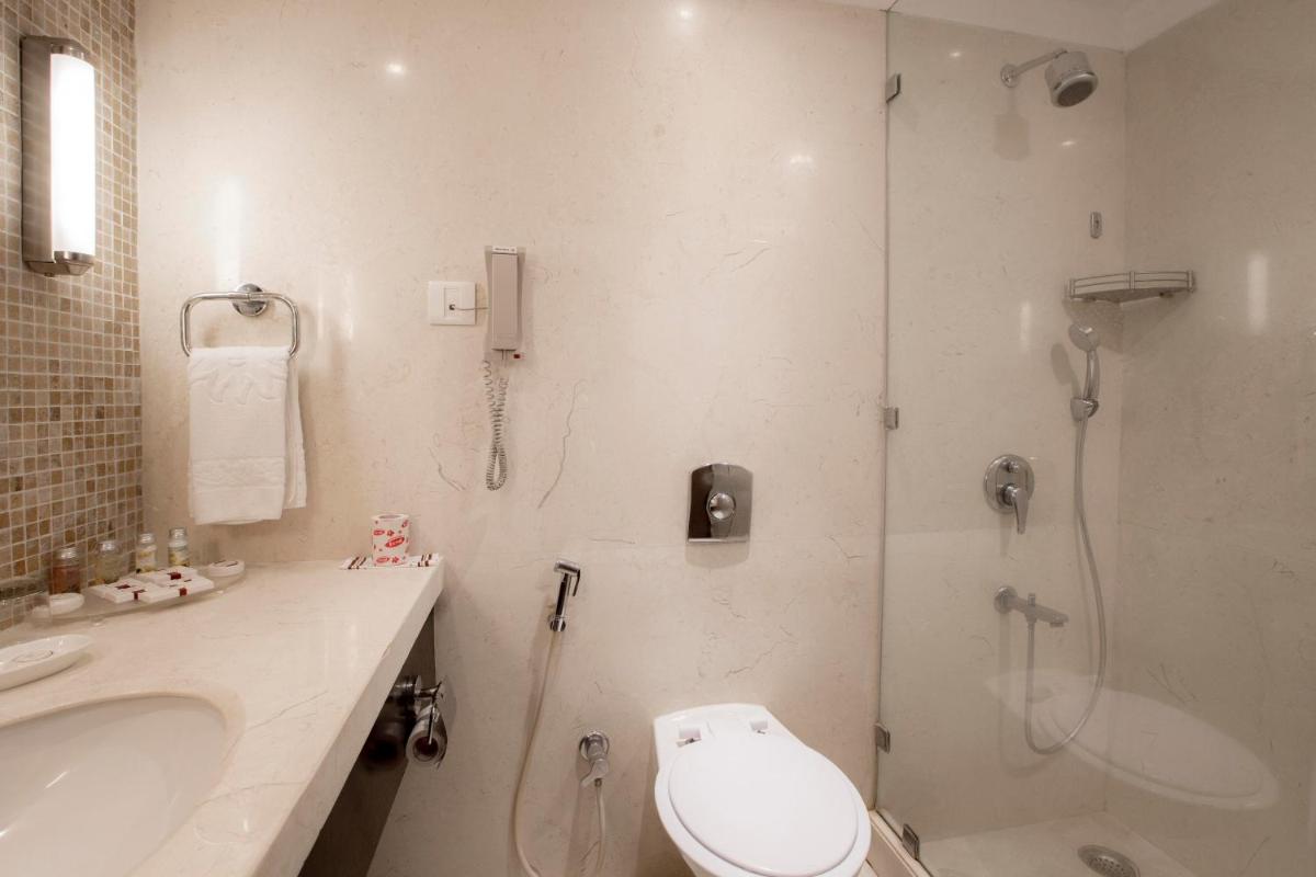 a bathroom with a shower and a toilet and a sink at Sun-n-Sand Mumbai Juhu Beach in Mumbai