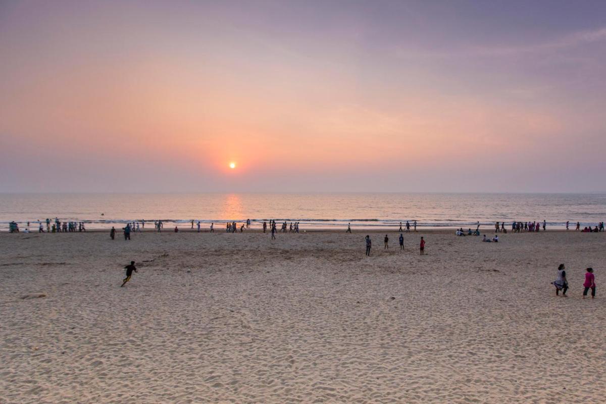 a group of people on the beach at sunset at Sun-n-Sand Mumbai Juhu Beach in Mumbai