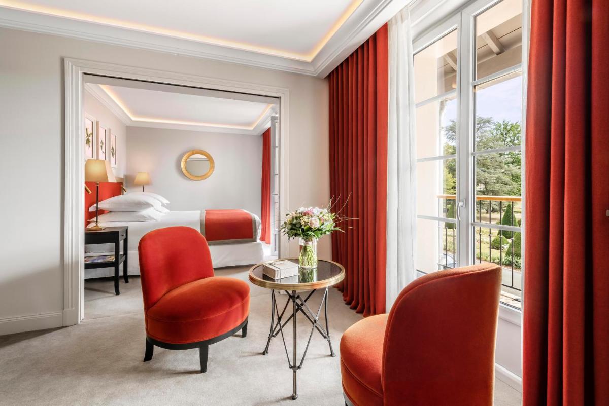 une chambre d'hôtel avec un lit, une table et des chaises dans l'établissement Château Saint-Jean, Relais & Châteaux, à Montluçon