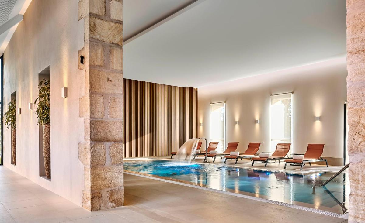 un hall d'accueil avec une piscine et des chaises dans l'établissement Château Saint-Jean, Relais & Châteaux, à Montluçon