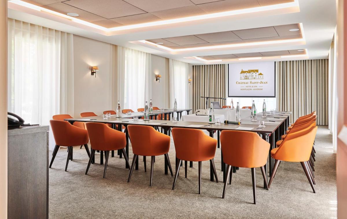 une salle de conférence avec une grande table et des chaises dans l'établissement Château Saint-Jean, Relais & Châteaux, à Montluçon 36 autres photos