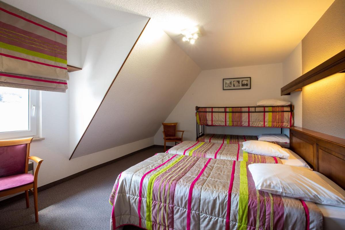 une chambre avec un lit et une chaise dans une pièce dans l'établissement Hôtel Restaurant et Spa Au Tilleul, à Labaroche