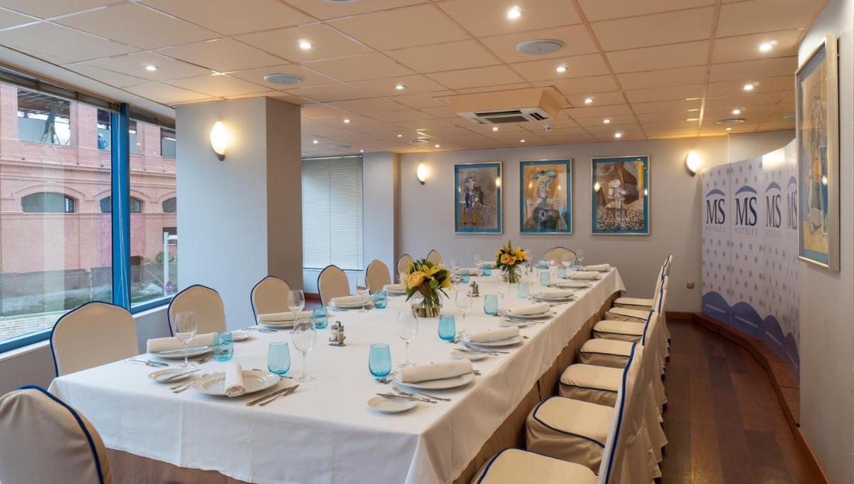Una sala de conferencias con una mesa larga con mesas y sillas blancas. en Hotel MS Maestranza Málaga, en Málaga 49 fotos más