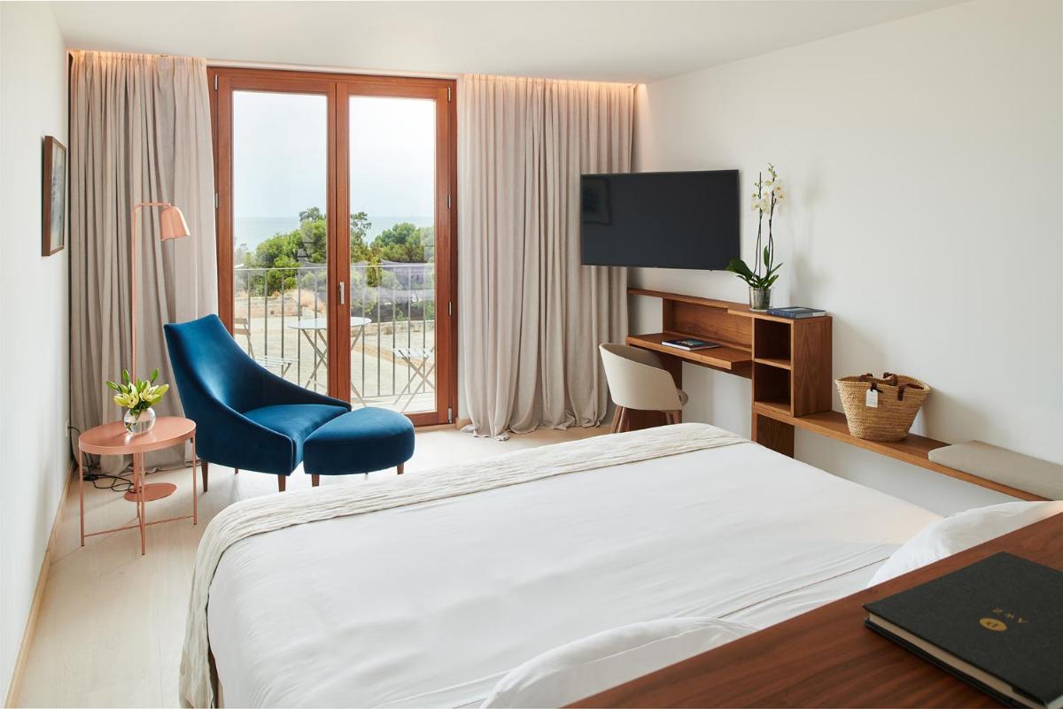 Una habitación de hotel con una cama, un escritorio y un televisor. en Es Princep - The Leading Hotels of the World, en Palma de Mallorca