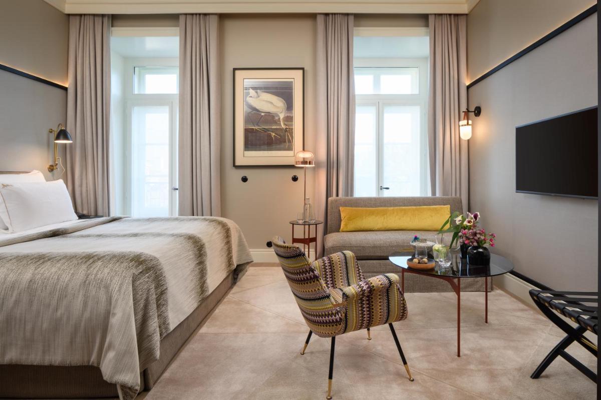 um quarto de hotel com uma cama e uma cadeira em Bairro Alto Hotel em Lisboa mais 89 fotografias