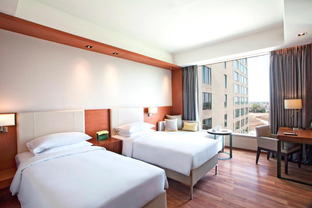 a hotel room with two beds and a desk at Hyatt Regency Amritsar Hotel & Spa in Amritsar