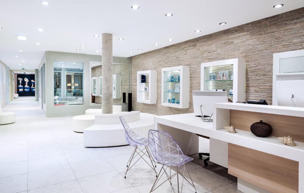 un hall avec des bureaux blancs et des chaises bleues dans l'établissement Spa Marin Du Val Andre Thalasso Resort, à Pléneuf-Val-André