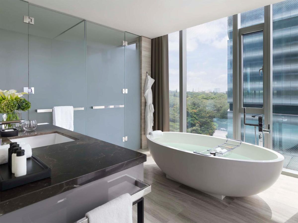 a bathroom with a tub and a large window at Four Seasons Hotel Bengaluru at Embassy ONE in Bengaluru a bathroom with a tub and a large window at Four Seasons Hotel Bengaluru at Embassy ONE in Bengaluru