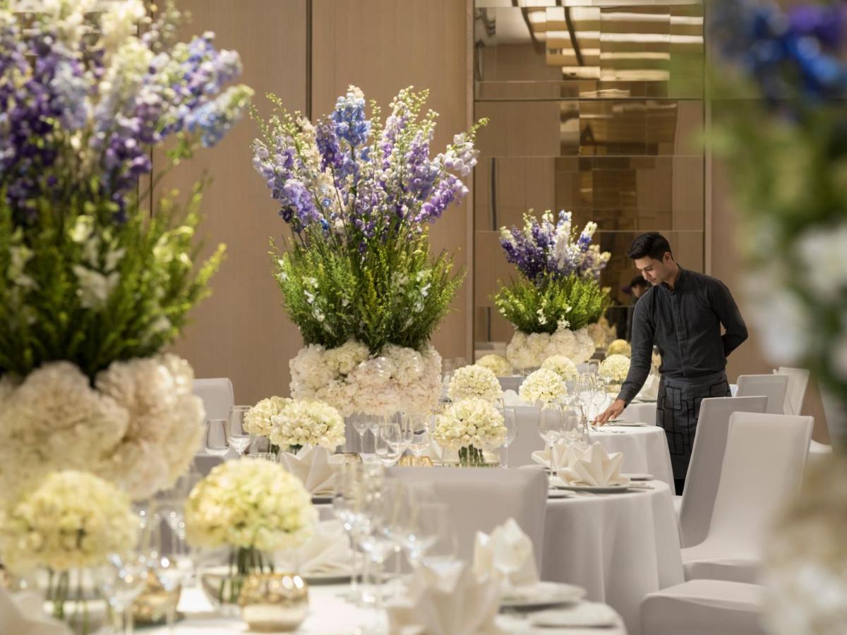 a man standing in front of a table with flowers at Four Seasons Hotel Bengaluru at Embassy ONE in Bengaluru a man standing in front of a table with flowers at Four Seasons Hotel Bengaluru at Embassy ONE in Bengaluru