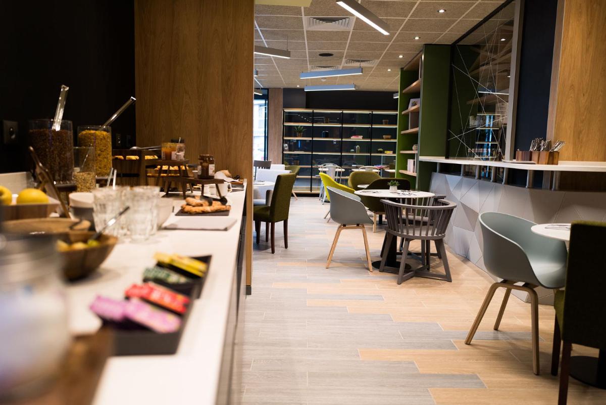 un restaurant avec des tables et des chaises ainsi qu'un comptoir de nourriture dans l'établissement Hotel Campanile Montpellier Centre St Roch, à Montpellier