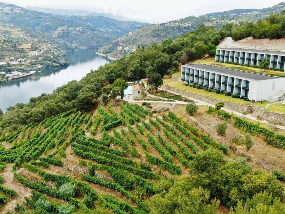 um edifício em uma colina ao lado de um rio em Douro Palace Hotel Resort & SPA em Baião