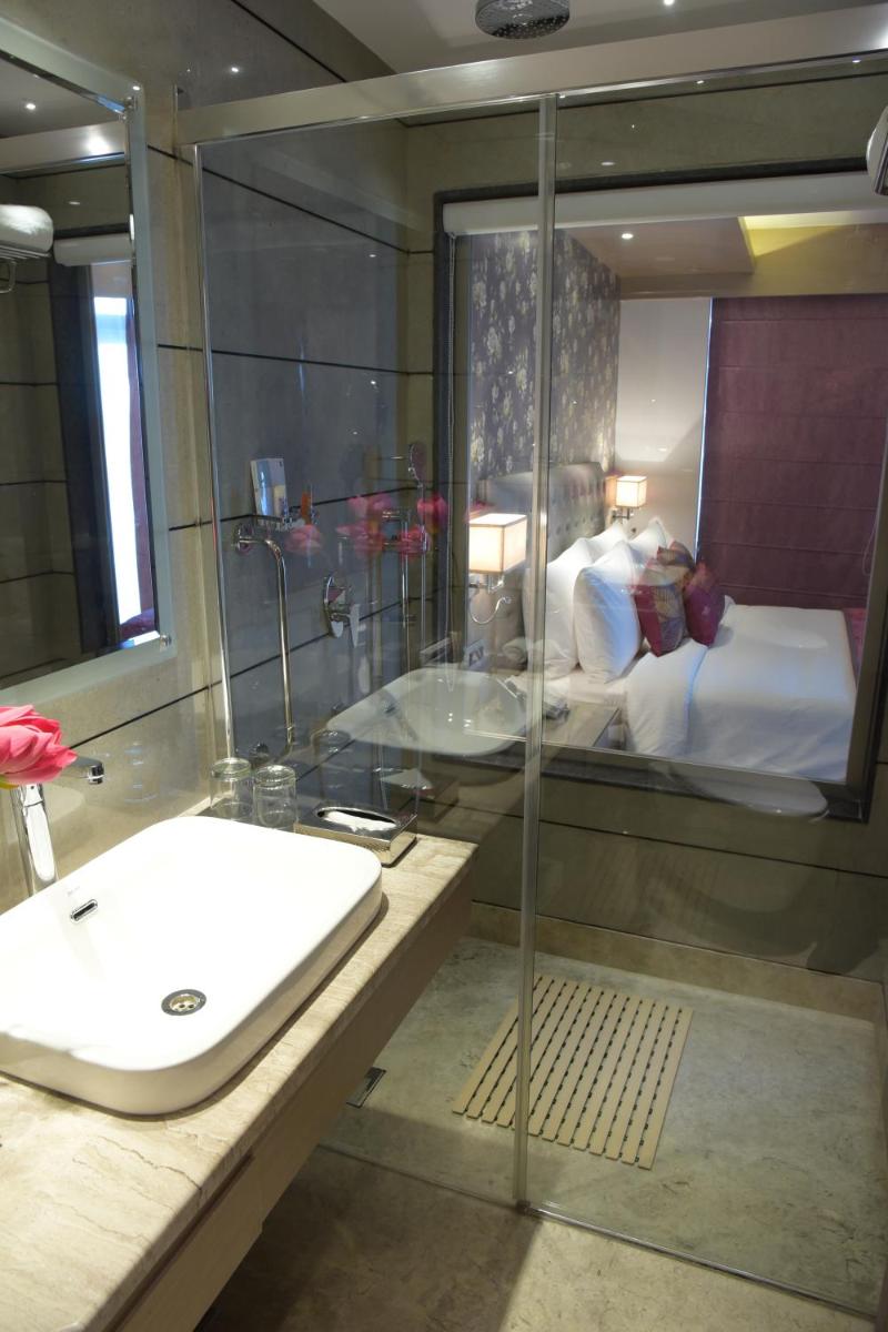 a bathroom with a sink and a shower and a bed at Welcomhotel by ITC Hotels, Shimla in Shimla