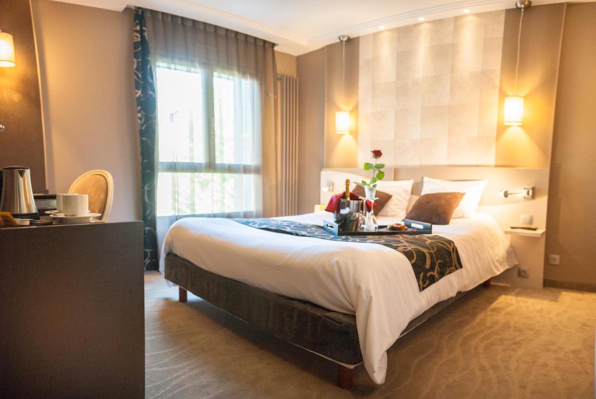 une chambre d'hôtel avec un lit et une fenêtre dans l'établissement Logis Hôtel Restaurant Le Fruitier, à Villedieu-les-Poêles 82 autres photos