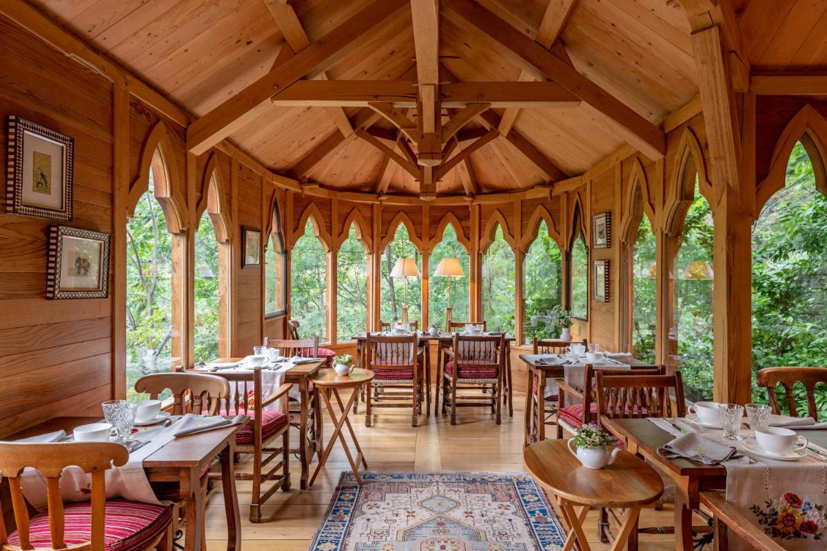 une salle à manger avec des tables et des chaises en bois dans l'établissement Château De Riell, à Molitg-les-Bains