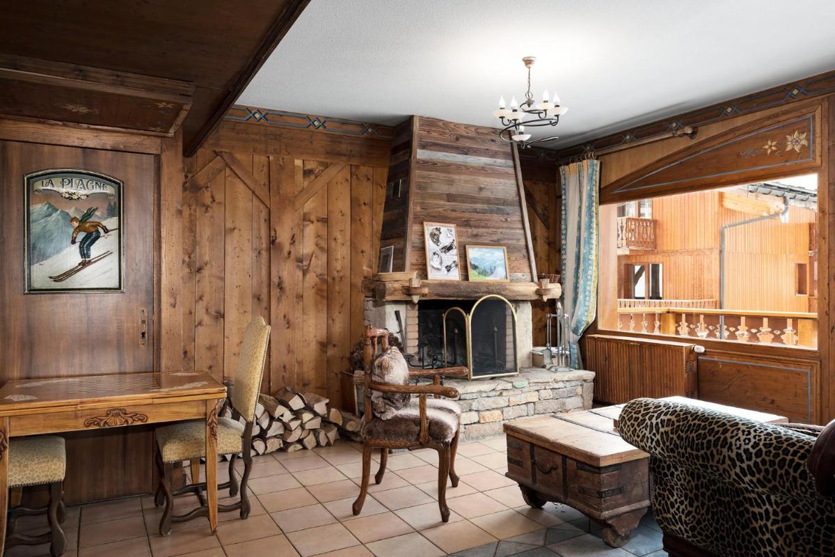 Elle comprend un salon doté de murs en bois et d'une cheminée. dans l'établissement Hôtel Les Balcons Village, à Belle Plagne