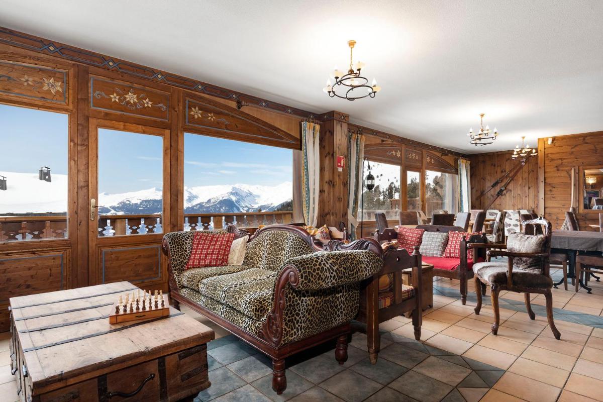 un salon avec des chaises, une table et des fenêtres dans l'établissement Hôtel Les Balcons Village, à Belle Plagne