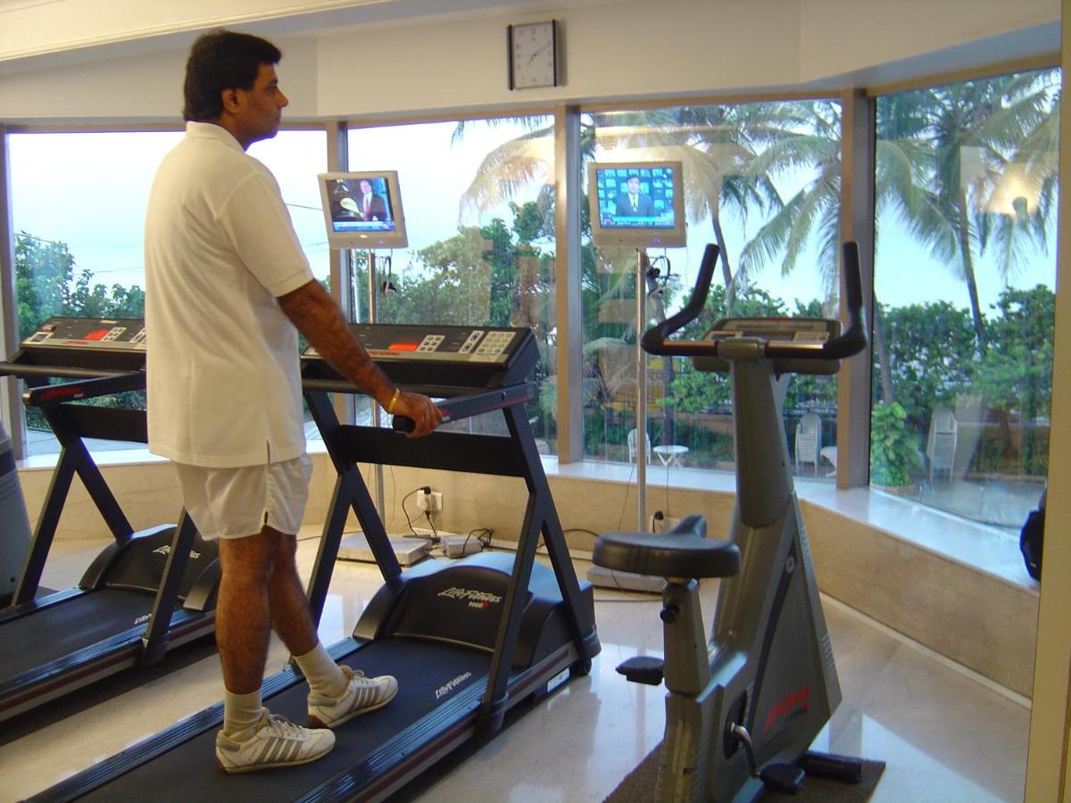 a man walking on a treadmill in a gym at Ramada Plaza By Wyndham Palm Grove in Mumbai