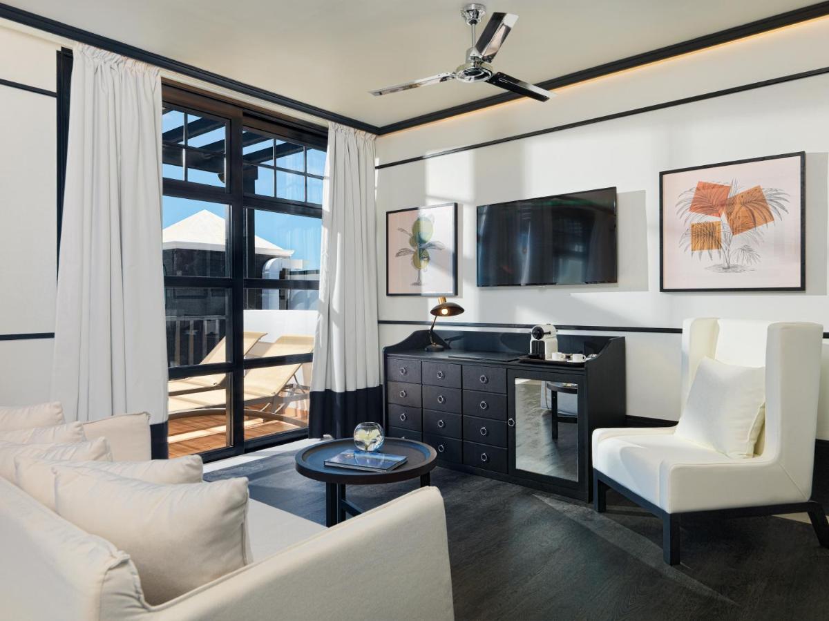 Una sala de estar con muebles blancos y una gran ventana. en H10 Rubicón Horizons Collection, en Playa Blanca