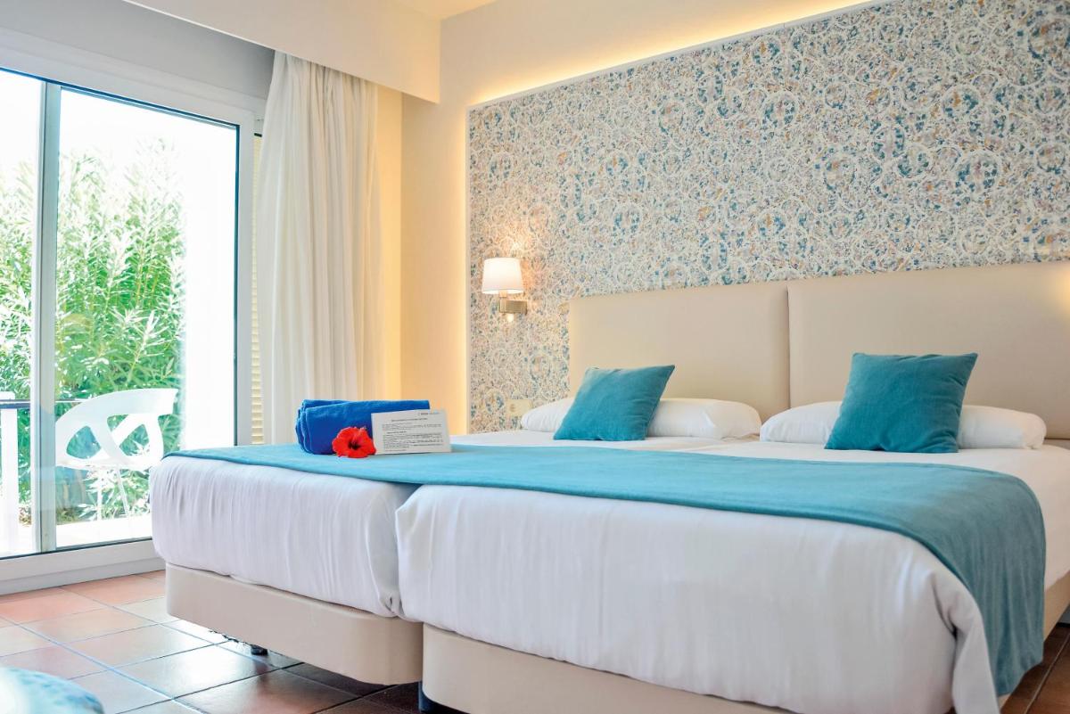 Un dormitorio con una cama grande con sábanas azules y blancas. en Aldiana Club Andalusien, en Chiclana de la Frontera 18 fotos más