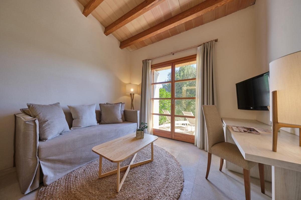 una sala de estar con un sofá y una mesa en Son Penya Adults Only Petit Hotel & Spa, en Sant Llorenç des Cardassar