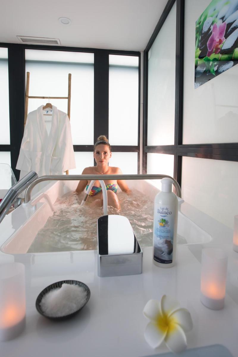 - un petit garçon dans une baignoire avec miroir dans l'établissement Eden Hotel & Spa, à Cannes
