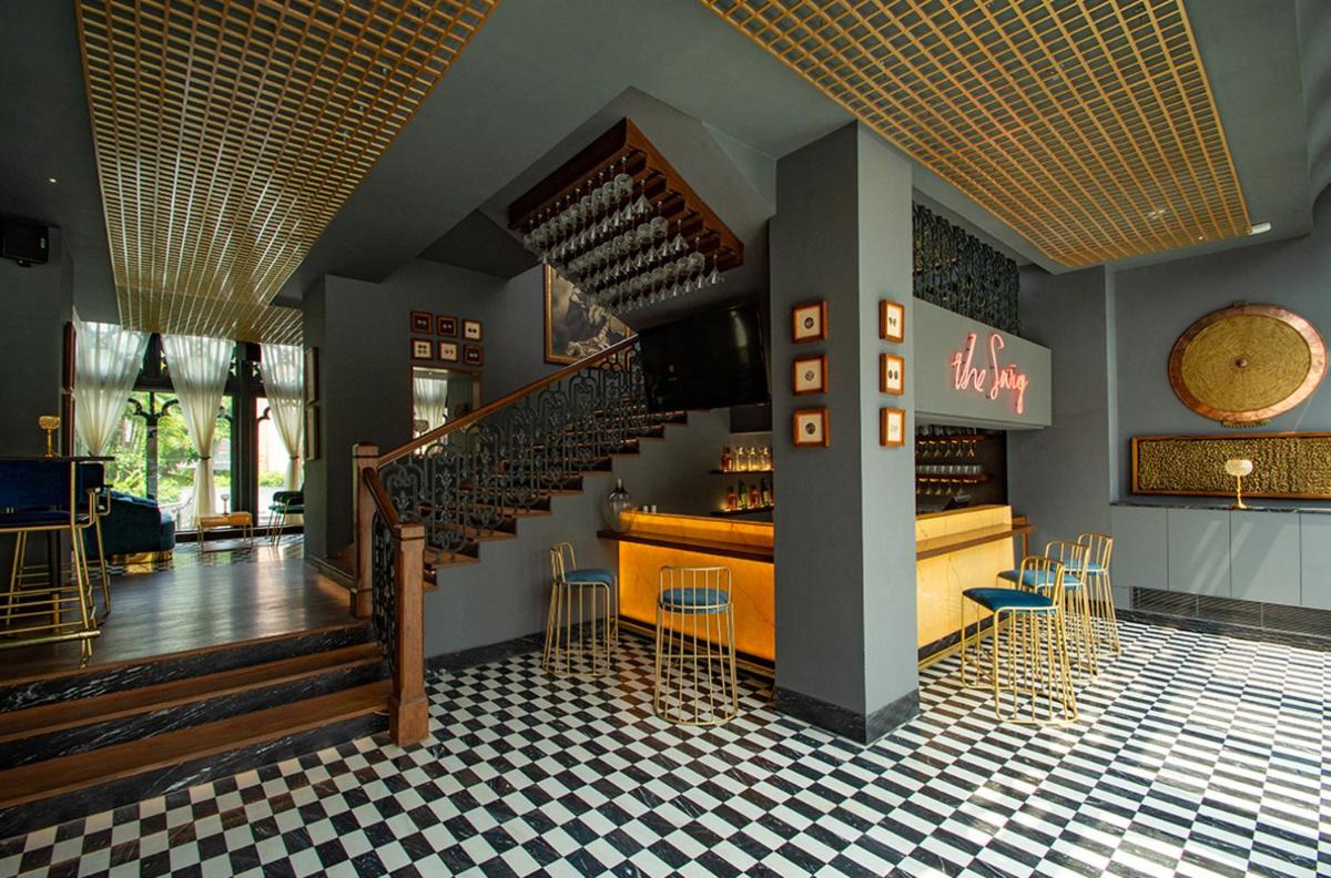 a restaurant with a staircase and a bar with chairs at Raajkutir - IHCL SeleQtions in Kolkata