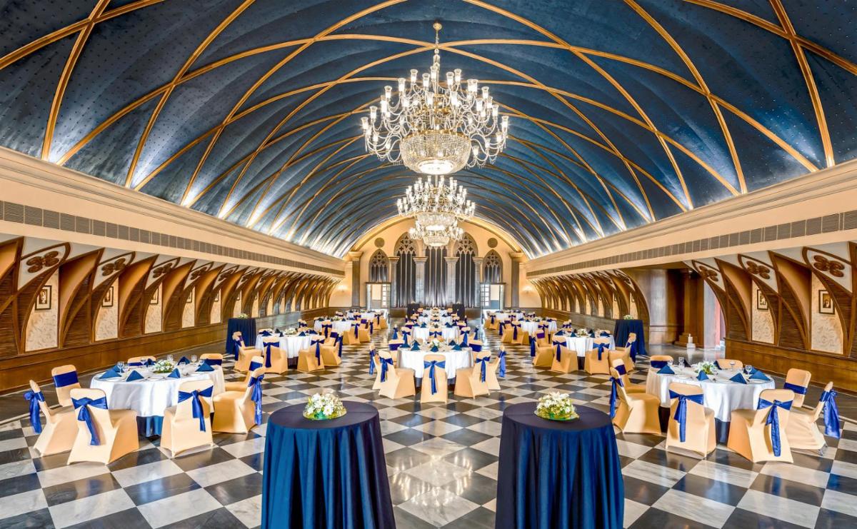 a banquet hall with tables and chairs and a chandelier at Raajkutir - IHCL SeleQtions in Kolkata a banquet hall with tables and chairs and a chandelier at Raajkutir - IHCL SeleQtions in Kolkata