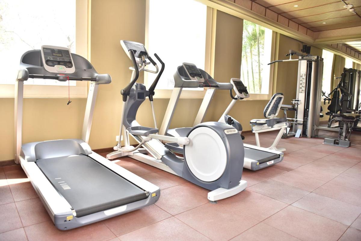 a gym with several cardio equipment in a room at Raajkutir - IHCL SeleQtions in Kolkata