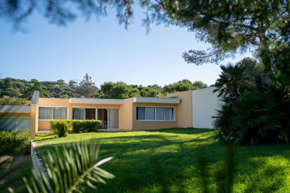une maison avec une pelouse verte devant dans l'établissement Résidence les Tourelles, à Sainte-Maxime