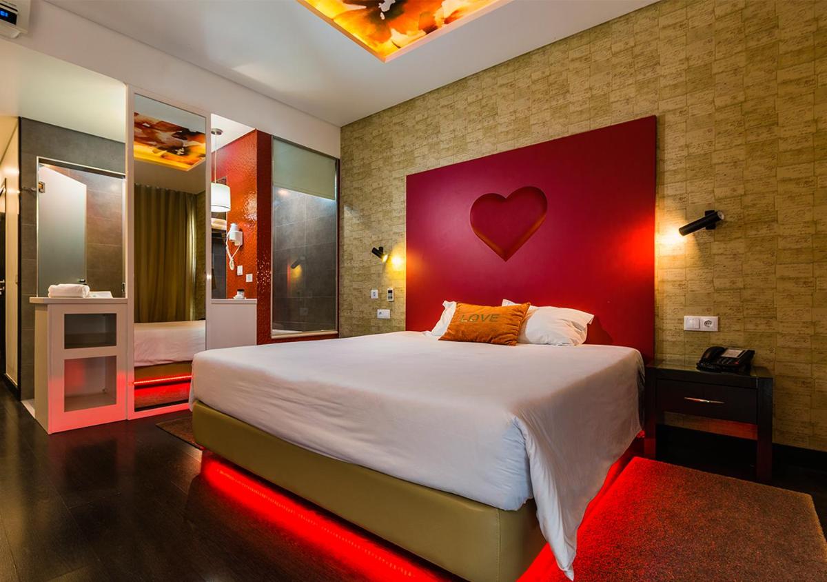 um quarto com uma cama grande com cabeceira vermelha em Lisotel - Hotel & Spa em Leiria mais 83 fotografias
