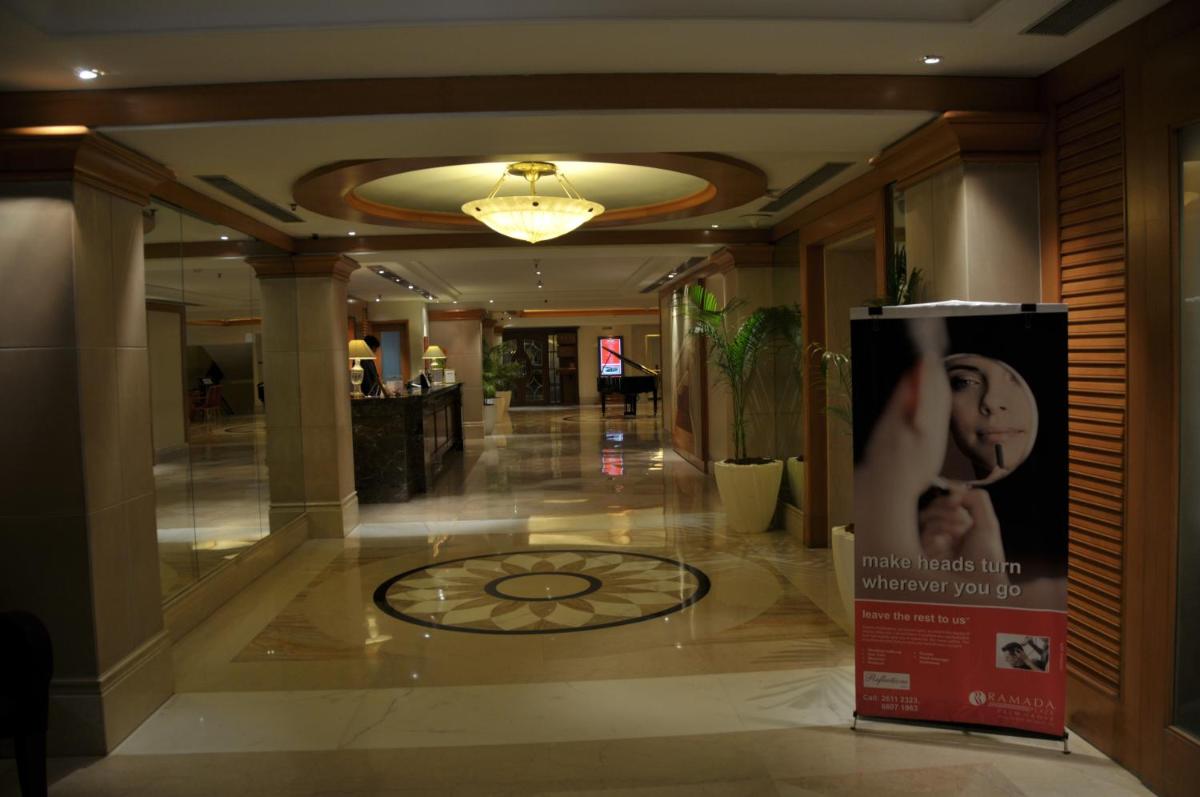 a hallway of a hotel with a clock on the floor at Ramada Plaza By Wyndham Palm Grove in Mumbai