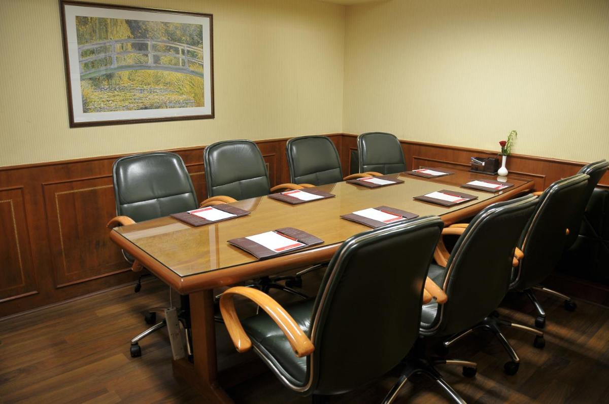 a conference room with a long table and chairs at Ramada Plaza By Wyndham Palm Grove in Mumbai