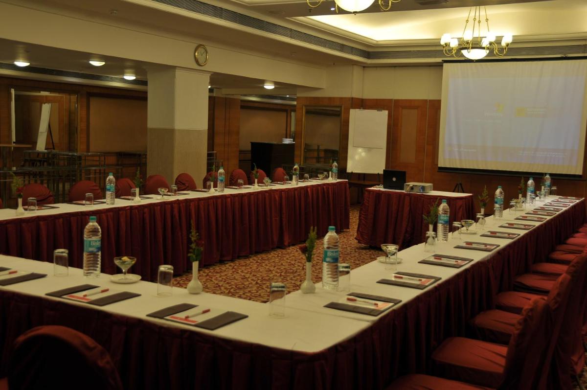 a row of tables in a conference room with chairs at Ramada Plaza By Wyndham Palm Grove in Mumbai