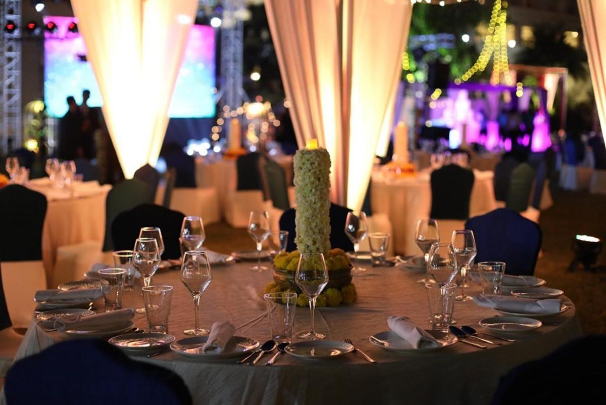 a table with wine glasses and plates on it at Greenpark Chennai in Chennai
