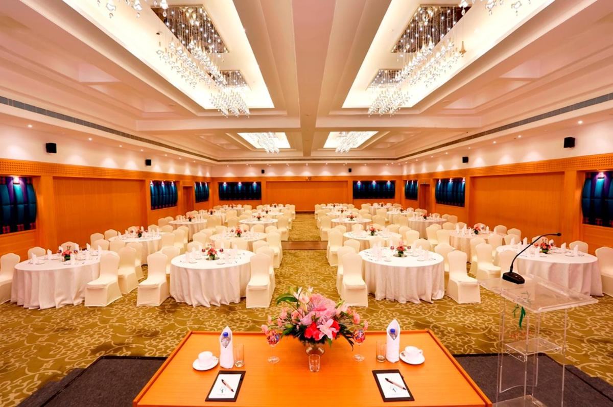 a banquet hall with white tables and white chairs at Greenpark Chennai in Chennai