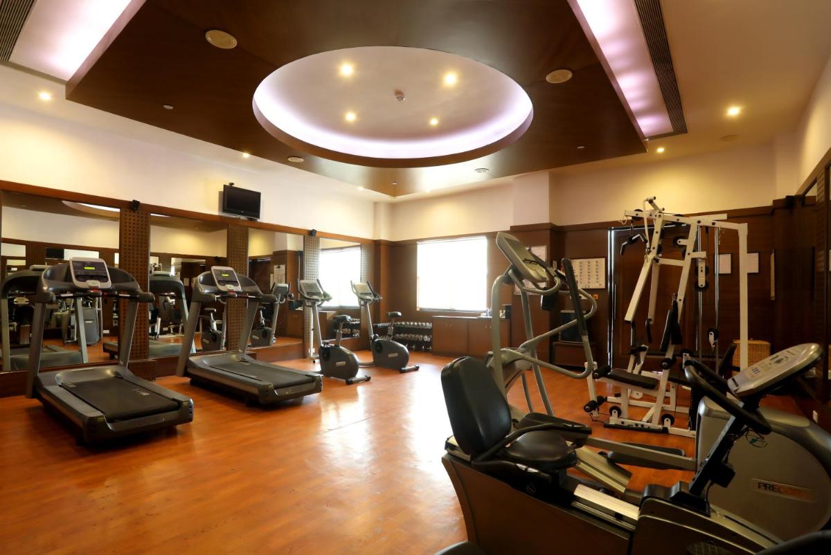 a gym with a bunch of treadms and cardio machines at Greenpark Chennai in Chennai