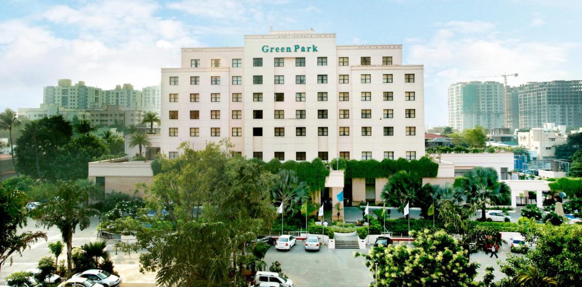 a large white building with cars parked in a parking lot at Greenpark Chennai in Chennai