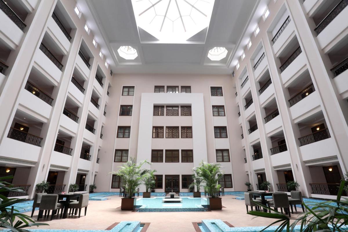 an empty lobby of a building with chairs and plants at Greenpark Chennai in Chennai