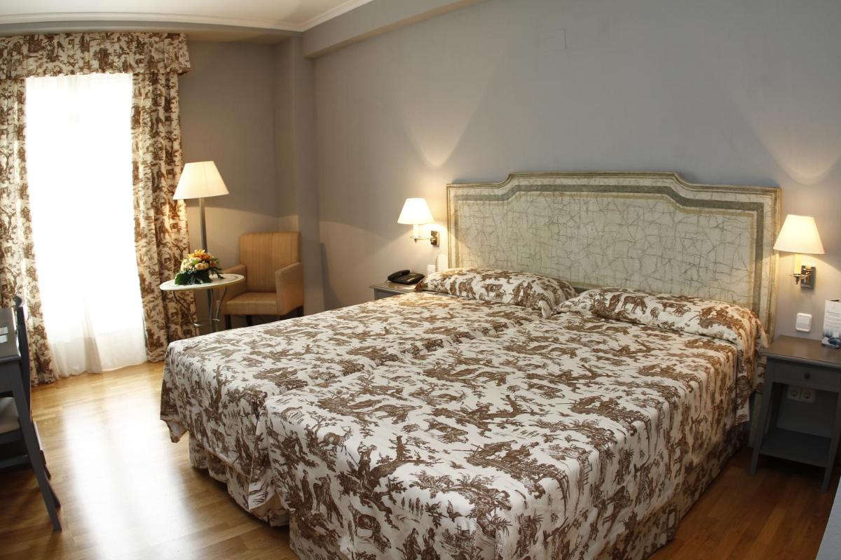Un dormitorio con una cama grande y una ventana. en Balneario de Mondariz, en Mondariz-Balneario