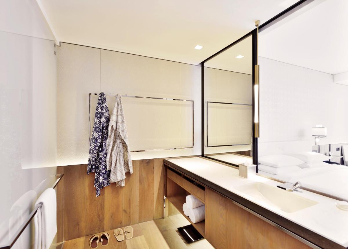 a bathroom with a sink and a mirror at Andaz Delhi, by Hyatt in New Delhi a bathroom with a sink and a mirror at Andaz Delhi, by Hyatt in New Delhi