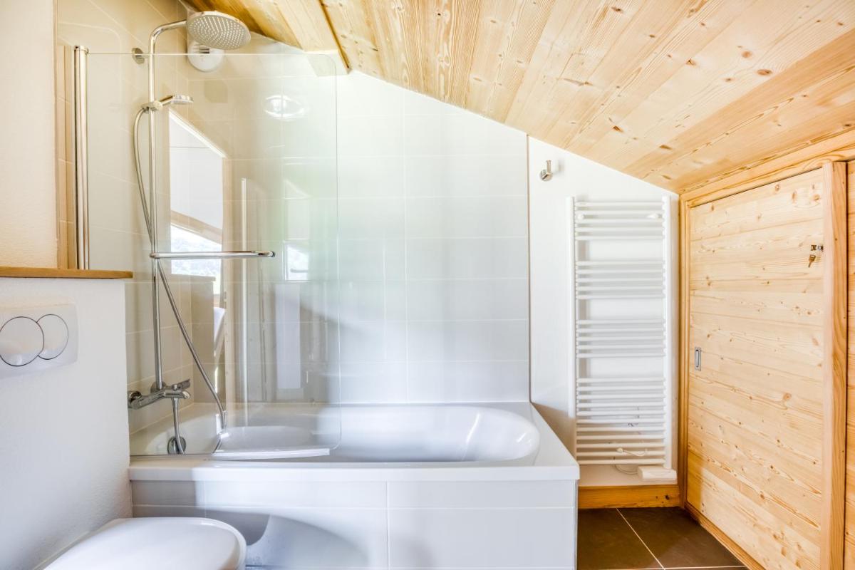 une salle de bain avec une baignoire blanche et des toilettes dans l'établissement TERRESENS - Les Fermes du Mont-Blanc, à Combloux