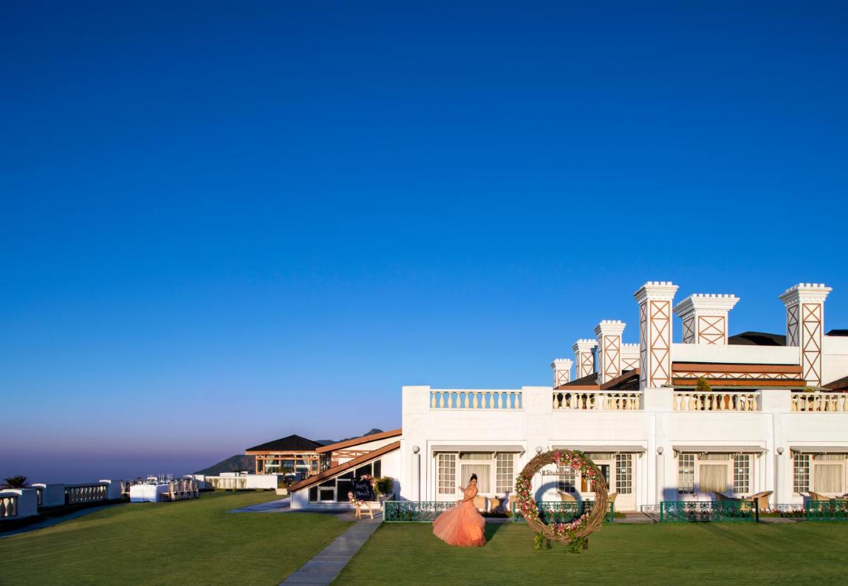 a large white house with a large yard at Jaypee Residency Manor in Mussoorie