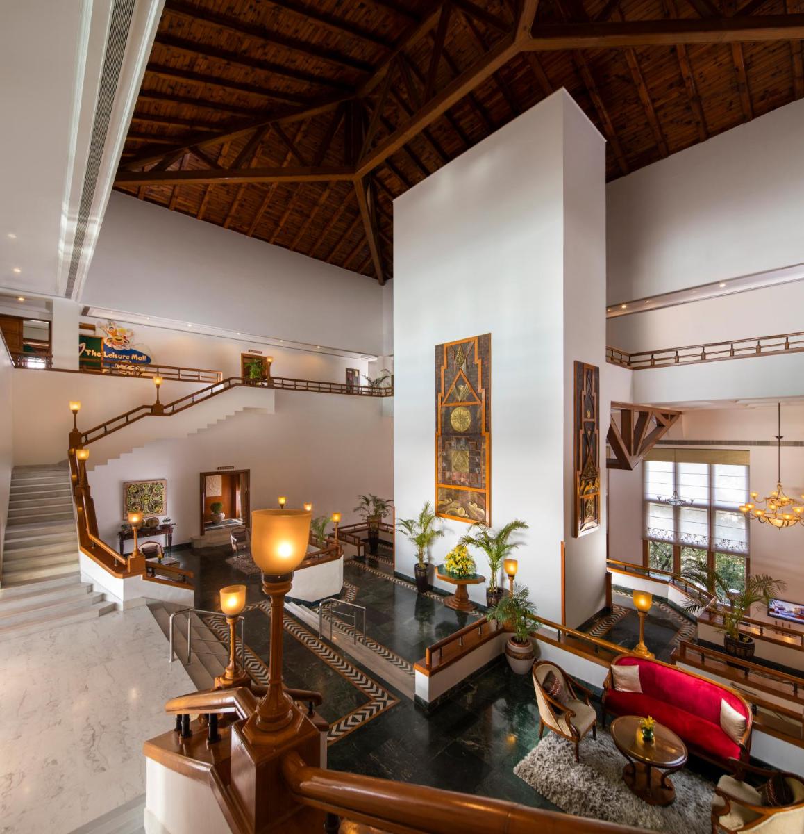 a living room with white walls and a wooden ceiling at Jaypee Residency Manor in Mussoorie